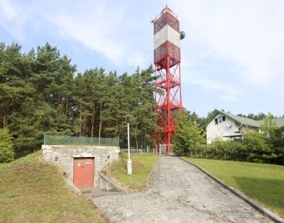 Žvilgsnis iš Šventosios švyturio: Baltijos jūros mėlis ir miestelis tarp medžių